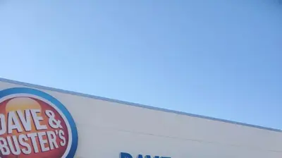A bright exterior shot of a Dave & Buster's building under a clear sky. Photo