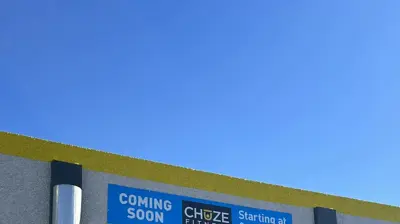 A building exterior displays a "COMING SOON CHOZE FITNESS" banner. Photo