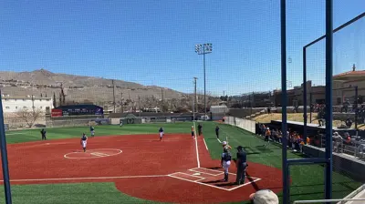 A wide view of a baseball game in progress on a sunny day. Photo