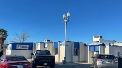 A light-colored building with blue trim. Photo