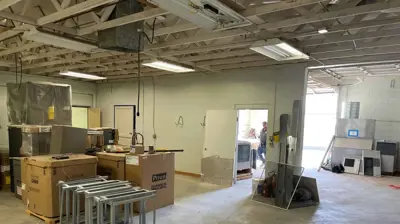 An indoor commercial space with concrete floors and an exposed ceiling. Photo